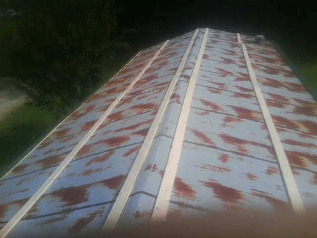 Rusted metal roof panels with new wood purlins before replacement — Storm Damage Roof Repair in Chocorua by Roofing Brothers