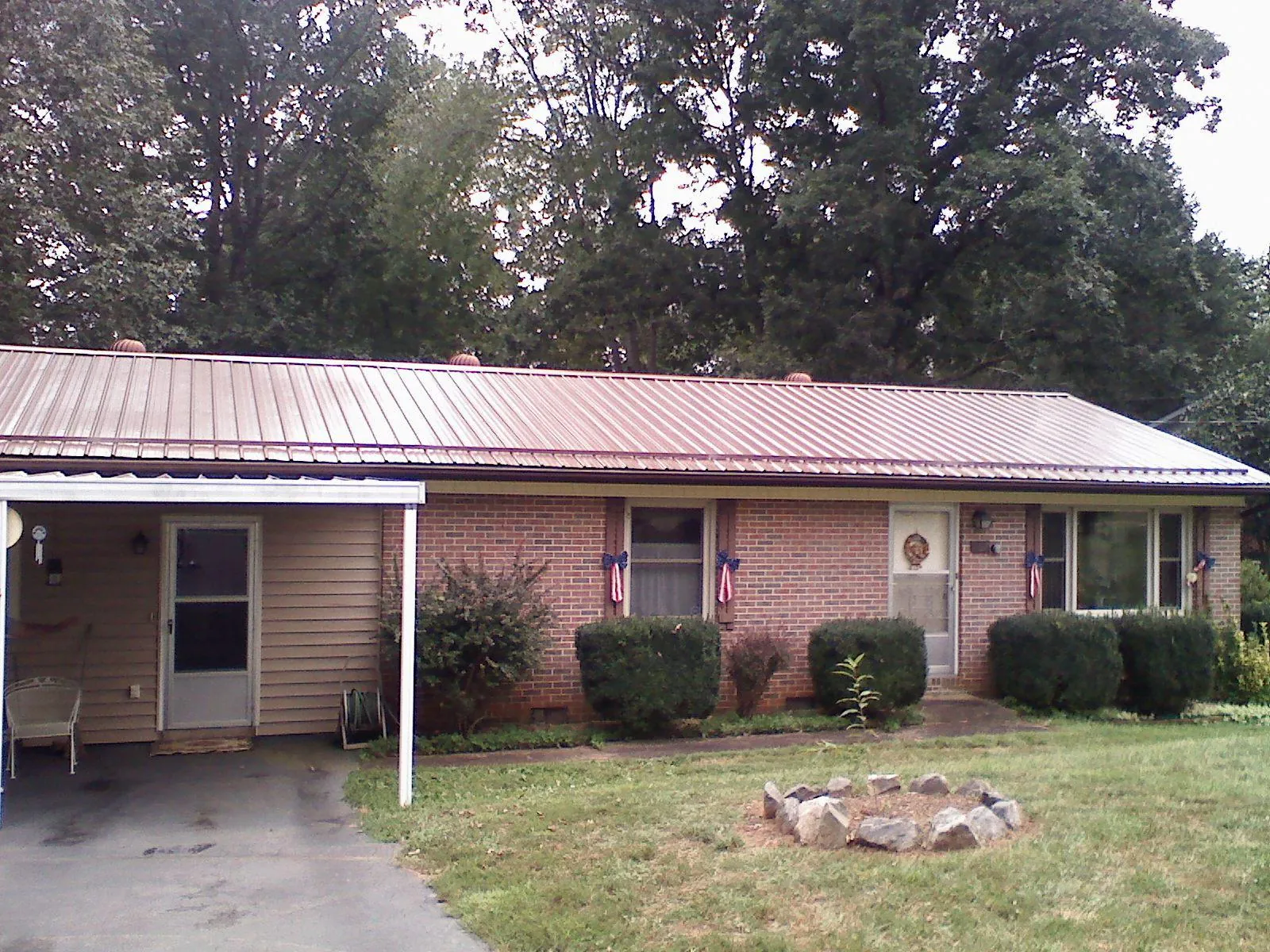 Bronze metal roof and carport on a brick ranch home — Roof Repair work by our crew in Chocorua